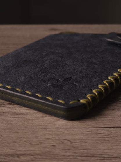 Hand saddle stitching detail on a handcrafted leather wallet. colors are navy & olive
